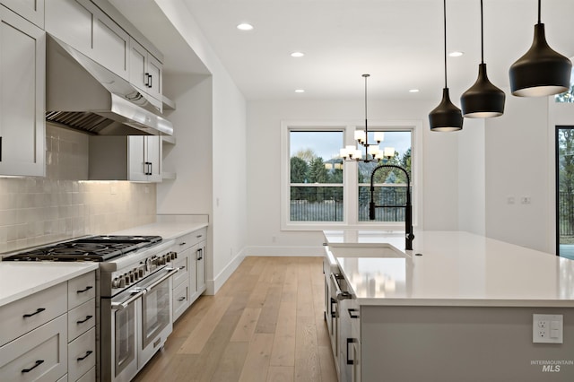 11444 N 17th Way, Boise, ID 83714 - kitchen featuring range with two ovens, under cabinet range hood, a chandelier, backsplash, and recessed lighting