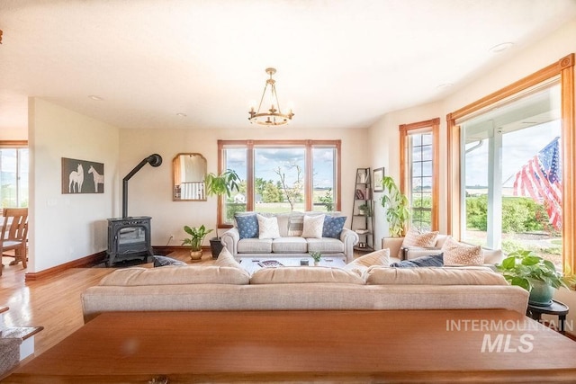 2350 Trail Rd, Moscow, ID 83843 - living area featuring a wood stove, wood finished floors, a chandelier, and baseboards