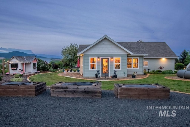 2350 Trail Rd, Moscow, ID 83843 - back of property at dusk with a garden, a yard, and roof with shingles