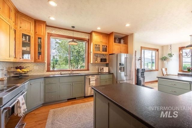 2350 Trail Rd, Moscow, ID 83843 - kitchen featuring appliances with stainless steel finishes, dark countertops, a sink, light wood-type flooring, and a textured ceiling