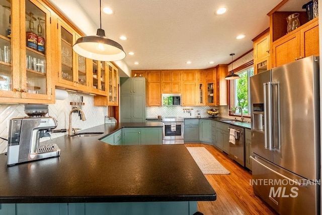 2350 Trail Rd, Moscow, ID 83843 - kitchen featuring appliances with stainless steel finishes, a sink, dark countertops, a peninsula, and recessed lighting