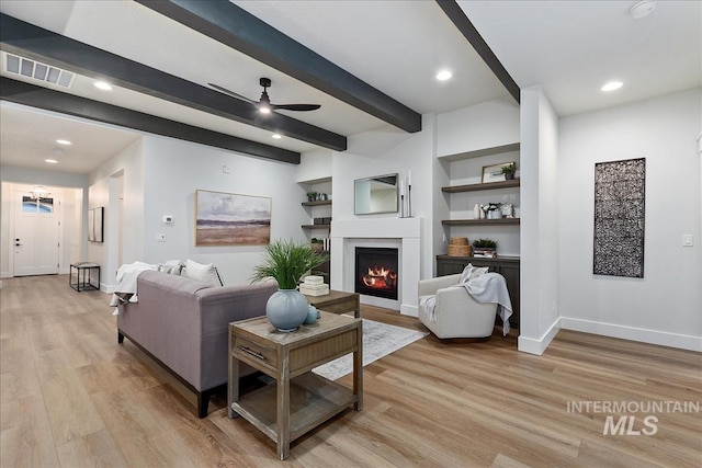 1071 E Star Pine Ln, Eagle, ID 83616 - living area featuring light wood finished floors, beam ceiling, a ceiling fan, baseboards, and a lit fireplace