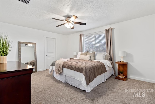 bedroom featuring ceiling fan, light carpet, and a textured ceiling