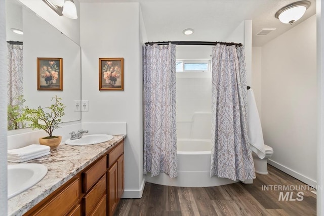 bathroom featuring hardwood / wood-style floors, shower / bath combo, and vanity