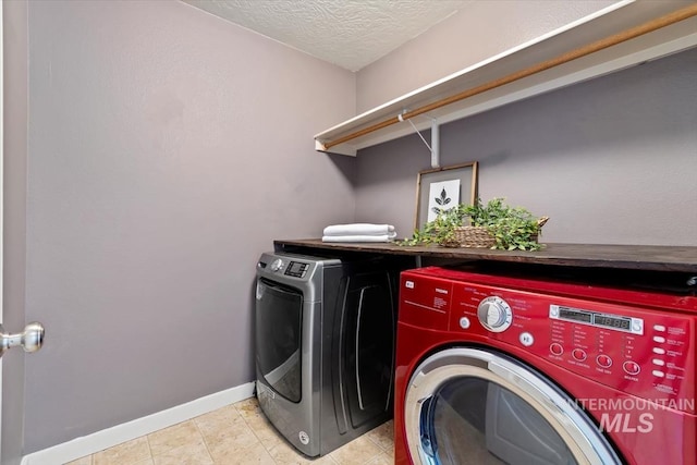 clothes washing area featuring a textured ceiling and washer and clothes dryer