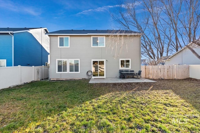 back of property with a lawn and a patio area