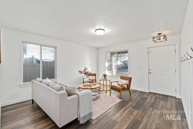 living room with a textured ceiling and dark wood-type flooring