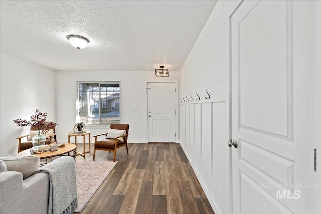 sitting room with dark wood-type flooring and a textured ceiling