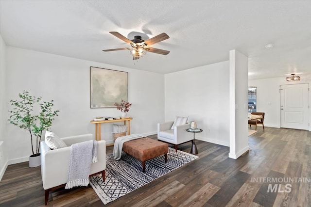 living area featuring dark wood-type flooring and ceiling fan