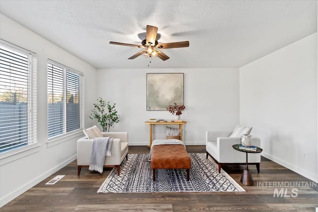 sitting room with ceiling fan and dark hardwood / wood-style floors