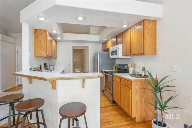 14325 W Comisky, Boise, ID 83713 - kitchen featuring stainless steel electric stove, white microwave, a kitchen breakfast bar, and light countertops
