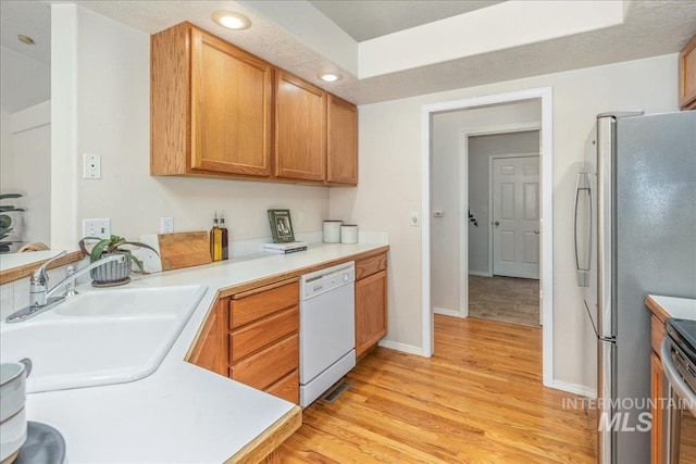 14325 W Comisky, Boise, ID 83713 - kitchen with white dishwasher, light wood-type flooring, freestanding refrigerator, light countertops, and range