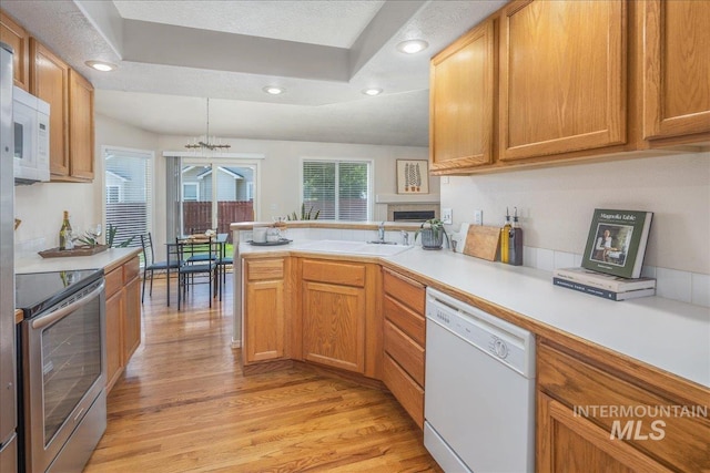 14325 W Comisky, Boise, ID 83713 - kitchen featuring white appliances, light wood finished floors, a peninsula, light countertops, and recessed lighting
