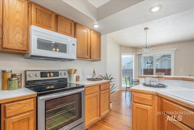 14325 W Comisky, Boise, ID 83713 - kitchen featuring stainless steel electric range oven, white microwave, light wood finished floors, light countertops, and recessed lighting