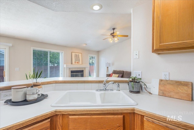 14325 W Comisky, Boise, ID 83713 - kitchen featuring light countertops, a glass covered fireplace, ceiling fan, open floor plan, and a textured ceiling