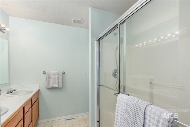 14325 W Comisky, Boise, ID 83713 - full bath featuring double vanity, a stall shower, tile patterned floors, and a textured ceiling