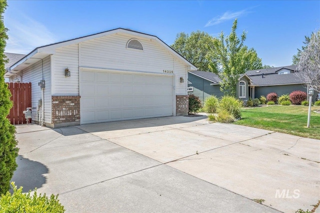 14325 W Comisky, Boise, ID 83713 - view of front of house featuring brick siding, driveway, and an attached garage