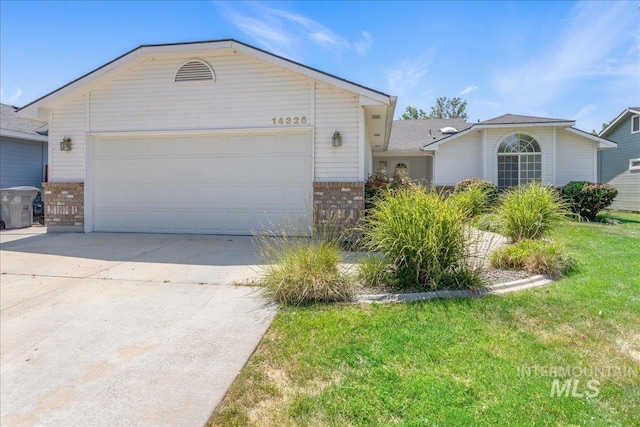 14325 W Comisky, Boise, ID 83713 - view of front facade featuring brick siding, driveway, an attached garage, and a front yard