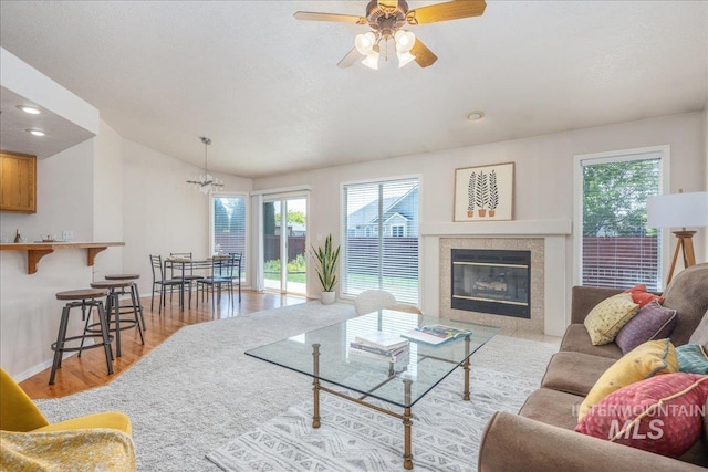 14325 W Comisky, Boise, ID 83713 - living area with vaulted ceiling, light wood-style floors, a ceiling fan, a tile fireplace, and recessed lighting