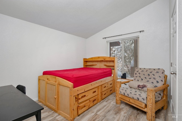 bedroom with light hardwood / wood-style flooring and lofted ceiling