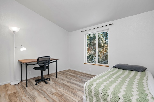 bedroom featuring light wood-type flooring and lofted ceiling