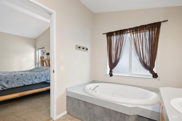 bathroom with vanity, a washtub, and vaulted ceiling