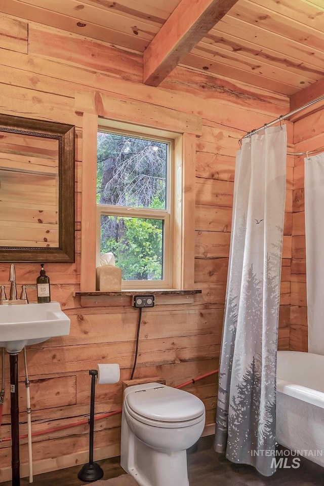 full bathroom with wooden ceiling, sink, wooden walls, and toilet