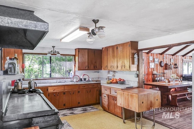 kitchen featuring a healthy amount of sunlight, extractor fan, lofted ceiling with beams, and ceiling fan