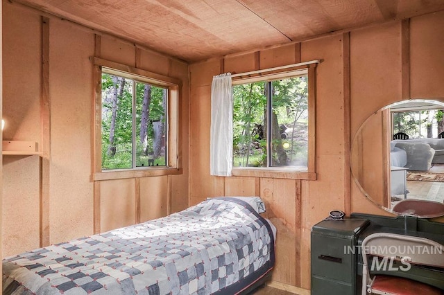 bedroom featuring wood walls and wood ceiling