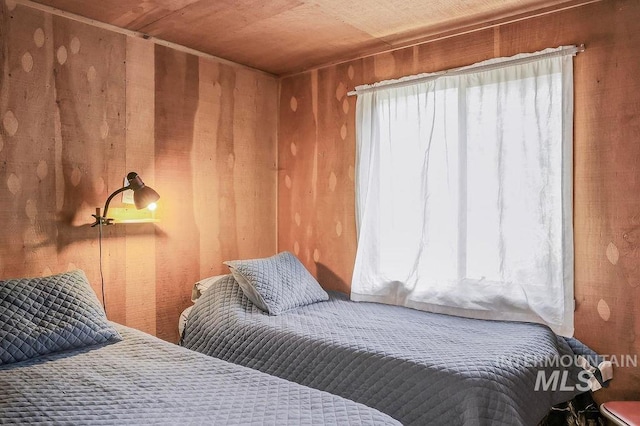 bedroom with wood walls and wood ceiling