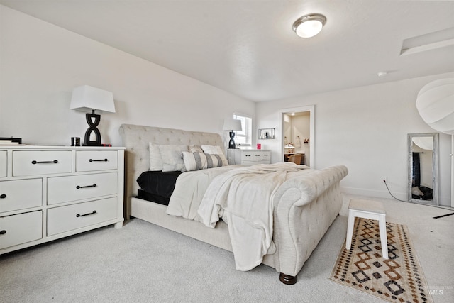 bedroom featuring ensuite bathroom and light carpet