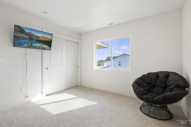 sitting room featuring light colored carpet