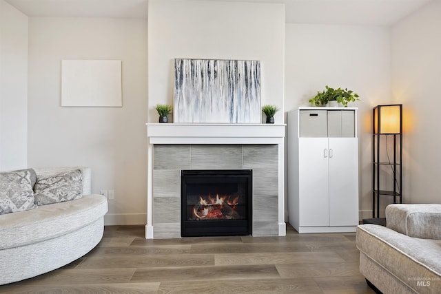 sitting room with hardwood / wood-style floors and a tile fireplace