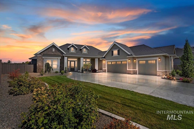 craftsman inspired home with a garage and a lawn