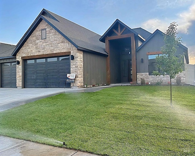 2253 Caribel St, Twin Falls, ID 83301 - view of front of home featuring stone siding, a garage, a front yard, board and batten siding, and driveway