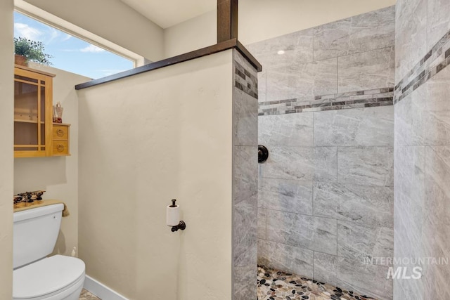 bathroom featuring toilet and tiled shower