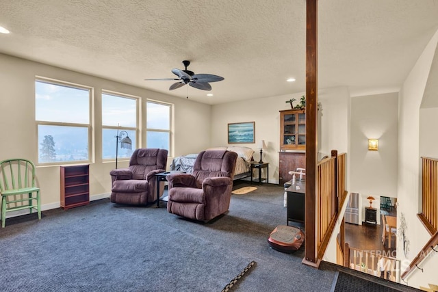 carpeted living room with ceiling fan and a textured ceiling