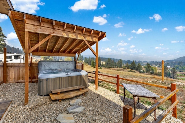 view of patio / terrace with a hot tub, a rural view, and central AC unit