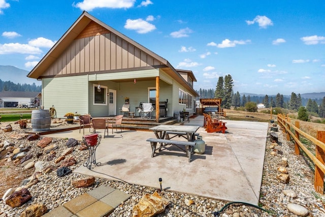 back of house featuring a mountain view and a patio