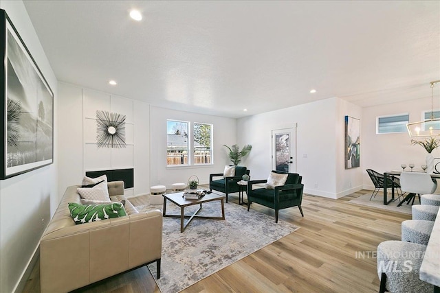 8126 N Breezy Ave, Boise, ID 83714 - living room with light hardwood / wood-style flooring and a notable chandelier