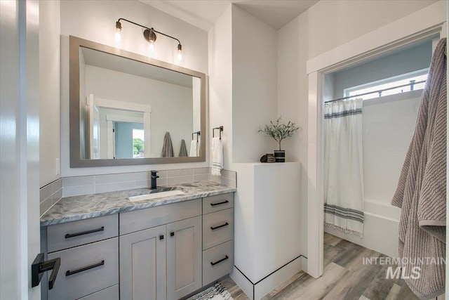 8126 N Breezy Ave, Boise, ID 83714 - bathroom with vanity, hardwood / wood-style floors, tasteful backsplash, and shower / bath combination with curtain