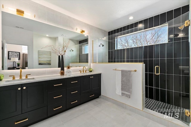 bathroom featuring tiled shower, vanity, and tile patterned floors