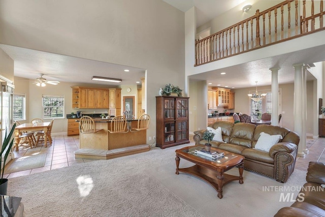 3283 Willow Cir, Twin Falls, ID 83301 - living area with light tile patterned floors, ceiling fan, a chandelier, light carpet, and decorative columns