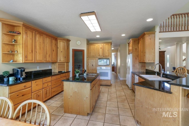 3283 Willow Cir, Twin Falls, ID 83301 - kitchen with white appliances, a kitchen island, a peninsula, light tile patterned floors, and open shelves