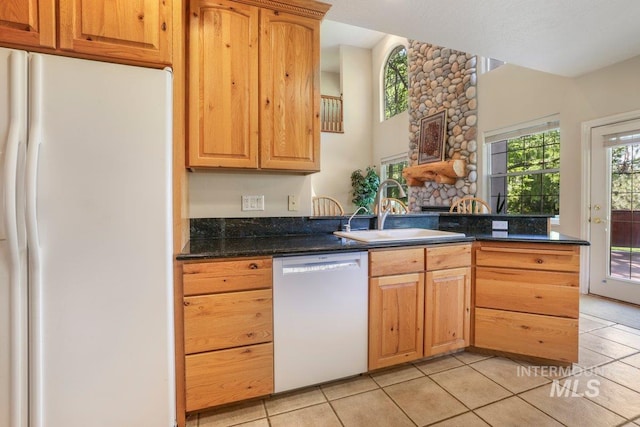 3283 Willow Cir, Twin Falls, ID 83301 - kitchen with white appliances, light tile patterned floors, a peninsula, and a stone fireplace