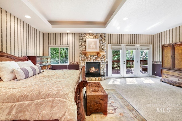 3283 Willow Cir, Twin Falls, ID 83301 - bedroom with wallpapered walls, access to outside, light colored carpet, a stone fireplace, and recessed lighting