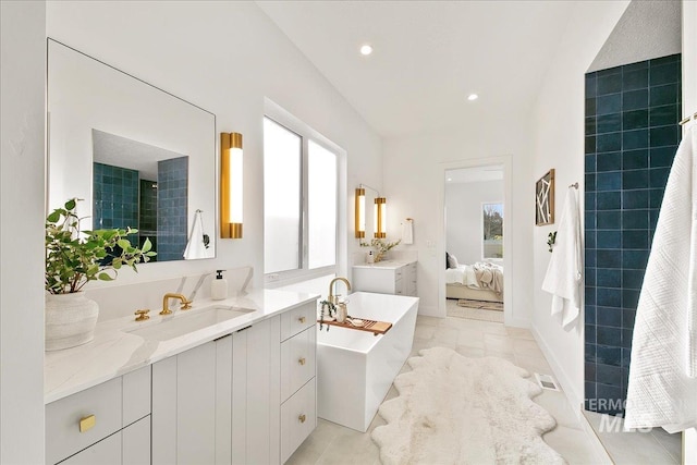 bathroom featuring vanity, a healthy amount of sunlight, and a tub to relax in