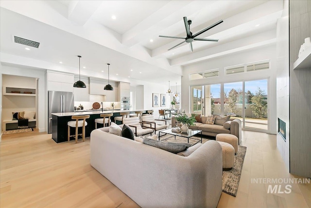 living room with light hardwood / wood-style floors, ceiling fan, and sink