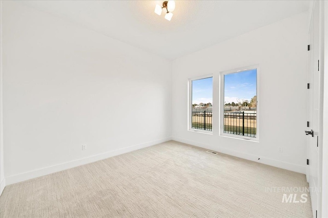 unfurnished room featuring light carpet