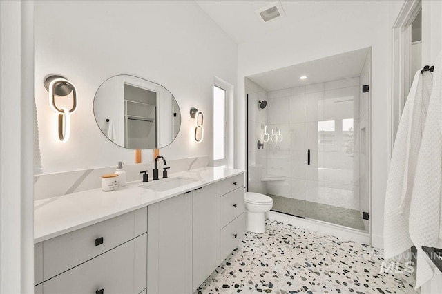 bathroom with vanity, toilet, and a shower with shower door